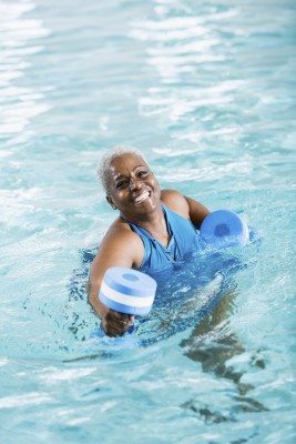 Senior black woman exercising, doing water aerobics